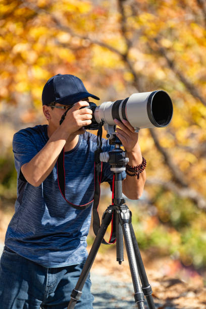 Man using a DSLR camera in a forest in autumn