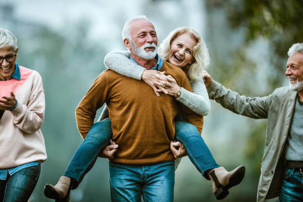 istock Playful mature couples having fun during autumn day in nature. 1438310224