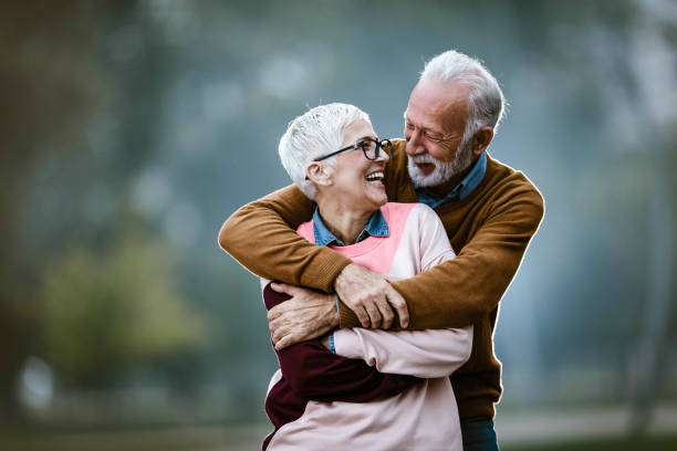 istock Happy embraced senior couple talking at the park. 1438310631