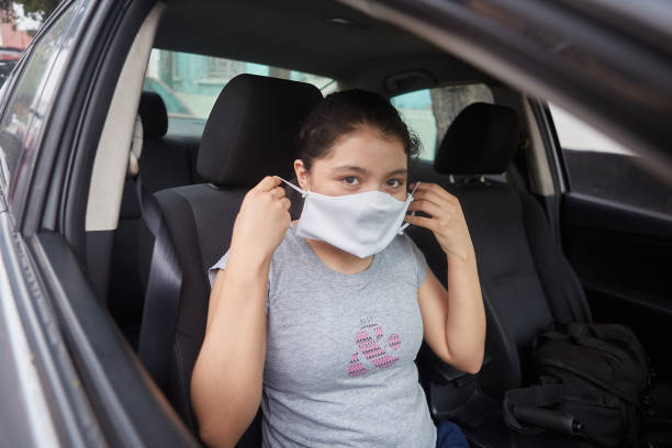 istock Young female wearing a face mask while sitting in the car 1438313081