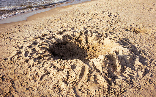 A hole in the sand on the beach