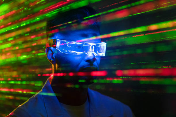 istock The handsome man in futuristic glasses standing on a laser rays background 1438314021