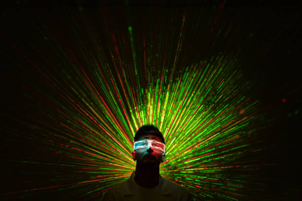 The guy in futuristic glasses standing on a colorful laser rays background