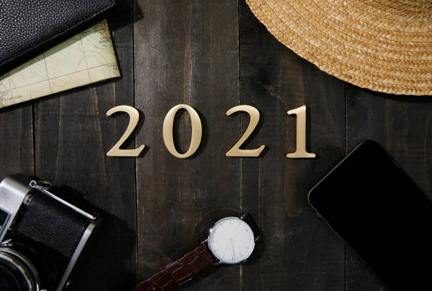 istock Camera, watch, smartphone, wallet, map and 2021 made with plastic numbers on a wooden table 1438315749