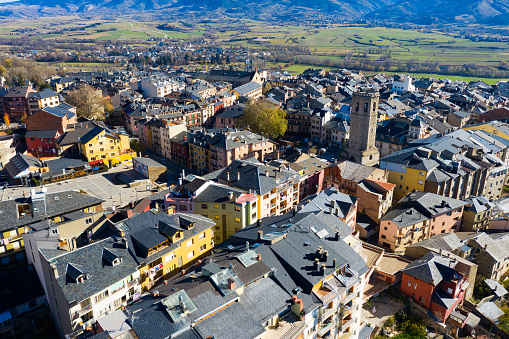 Panoramic aerial view of Puigcerda townscape overlooking medieval bell tower of ruined Santa Maria church in sunny autumn day, Girona, Spain