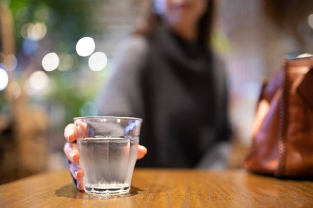 A woman holding water on the table