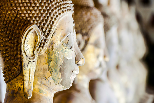 A closeup shot of an old chipped Buddha statue face