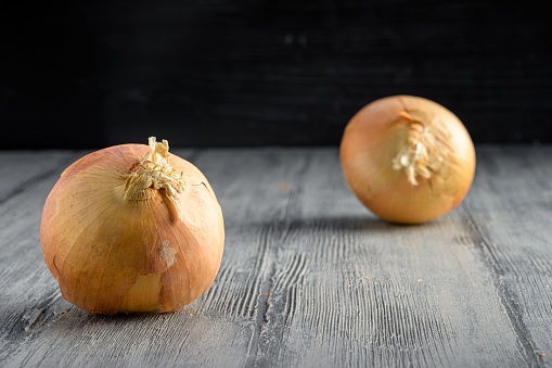 Two onions on a wooden table