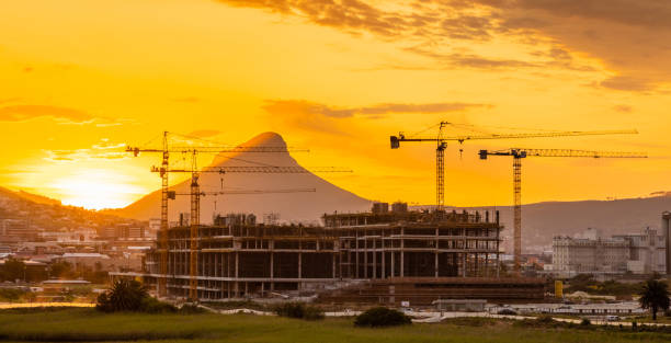 Construction cranes on building site at sunset in Cape Town, South Africa