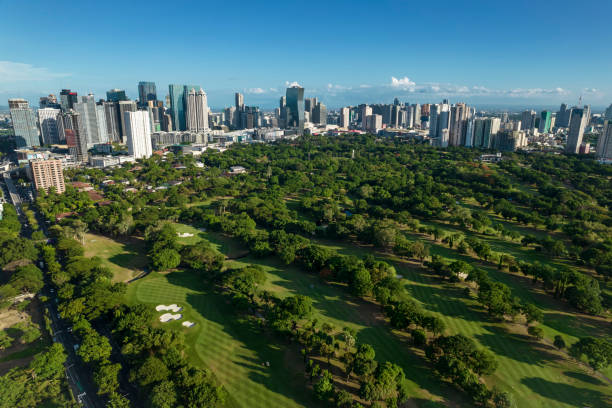 Mandaluyong, Metro Manila, Philippines - Aerial of the Wack Wack Golf and Country Club. Flanked by the surrounding skyscrapers forming the Ortigas and Boni skylines. Mandaluyong, Metro Manila, Philippines - May 2022: Aerial of the Wack Wack Golf and Country Club. Flanked by the surrounding skyscrapers forming the Ortigas and Boni skylines. wack stock pictures, royalty-free photos & images