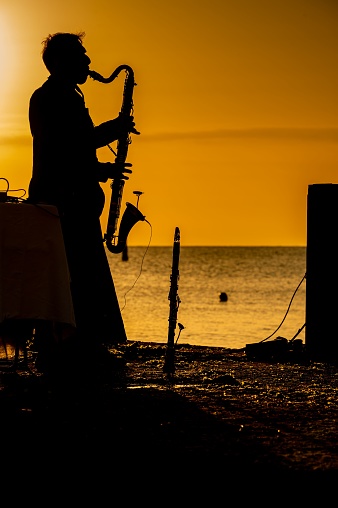 Pesaro, Italy – July 05, 2022: Italy, July 2022: concert at dawn in Pesaro with musical instrument and sea in the background in the Marche region