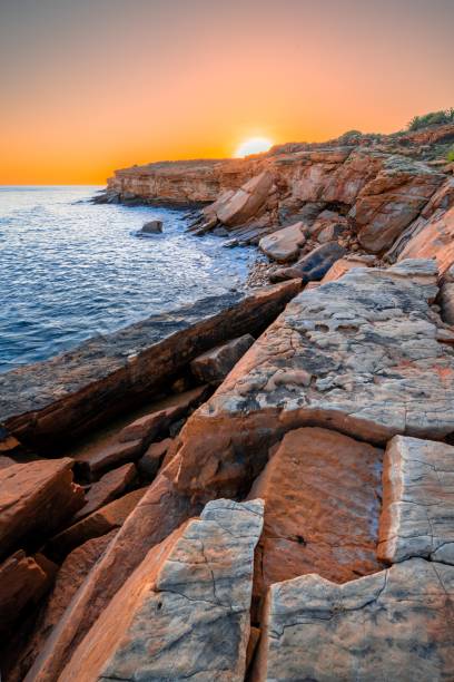 istock Beach with rocks and sands while the sun is setting 1438321288