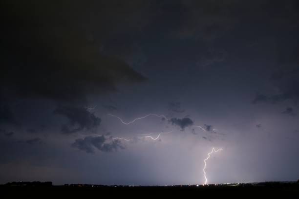 istock Beam of lightning in a clear night sky strikes a field 1438321338