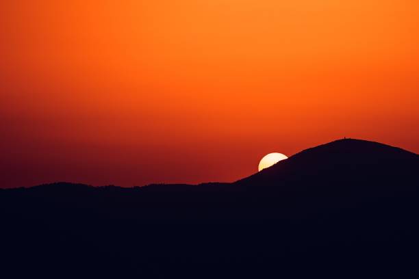 istock Sun setting behind a silhouette mountain in , Athens, Greece 1438321831