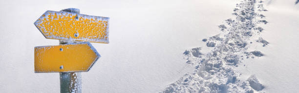 istock yellow opposite yellow signpost on tracks in fresh snow in panoramic view 1438321928