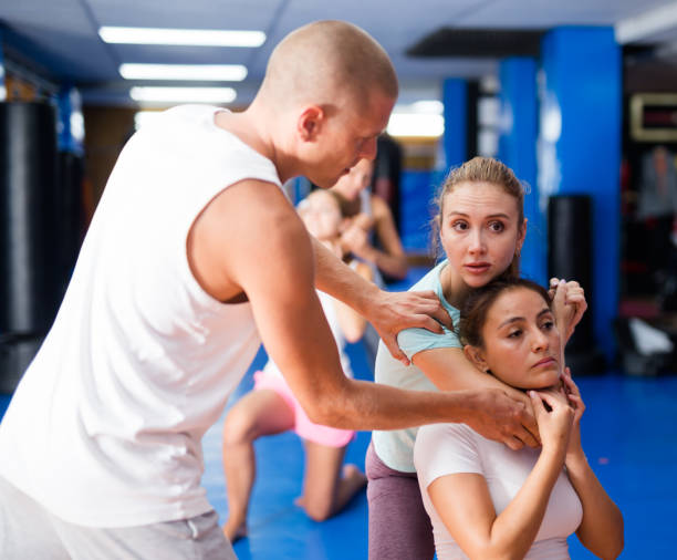 istock Self-defense instructor teaching women to perform guillotine choke 1438323659