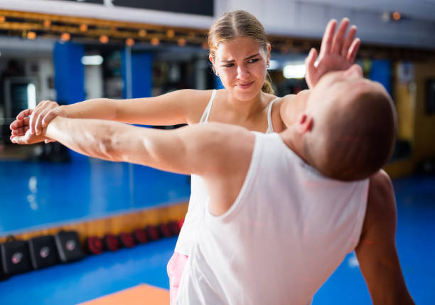 istock Young woman performing chin strike on man 1438323705