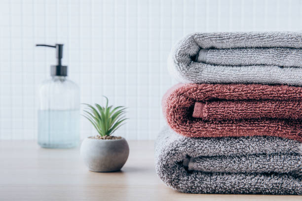 istock Towels. Clean fresh fluffy towels and bath accessories on table in bathroom 1438323813