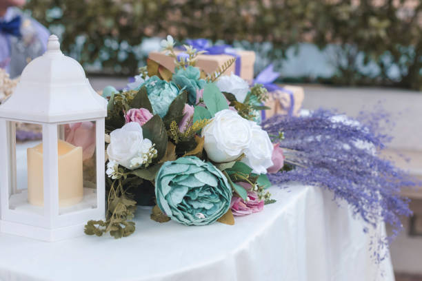 istock Beautiful wedding tabletop decoration. With sage green, blush, lavender and white colored roses and white candle lantern. 1438325210