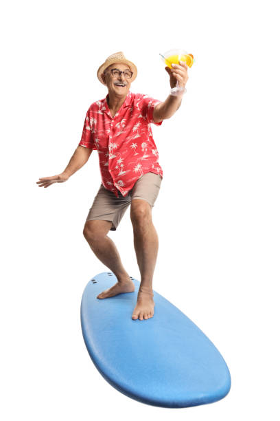 istock Mature man riding a surf board and holding a cocktail 1438330750