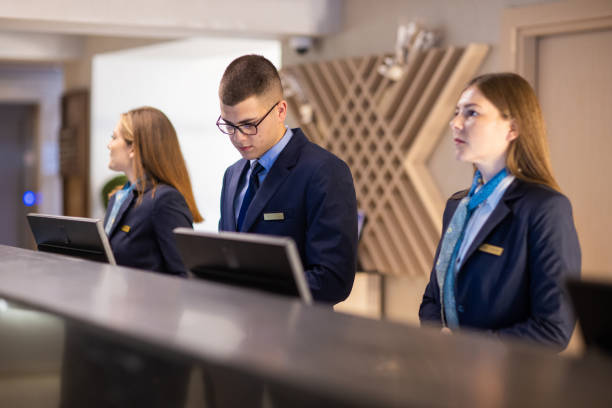 A group of hotel receptionists at a reception desk in a luxury hotel
