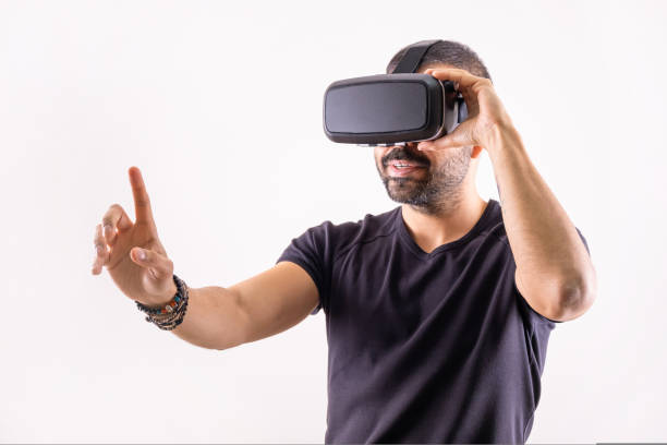 istock Young man in VR glasses headset gesturing portrait. Virtual reality, future technology, education video gaming 1438332541