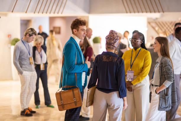 pessoas de negócios conversando no lobby do hotel antes de um evento de conferência de negócios - event convention center business hotel - fotografias e filmes do acervo