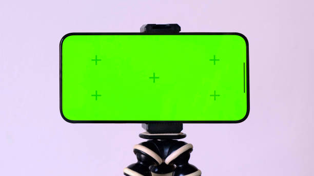 istock Online learning. Green screen of smartphone with VFX motion tracking markers on tripod at white background 1438334114