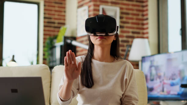 istock Asian person wearing futuristic VR goggles while interacting with cyber reality. 1438337928