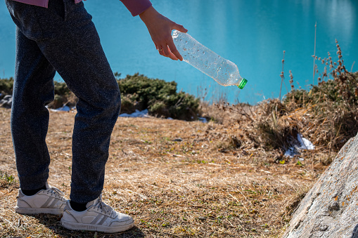 istock Cropped image of a woman picking up trash in a natural reserve 1438340609