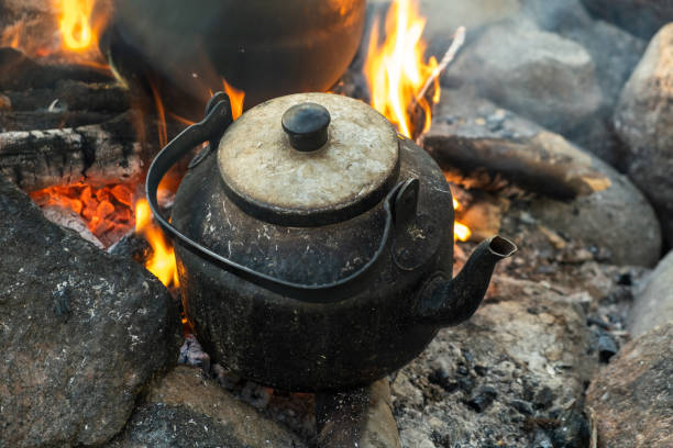 istock Campfire camp kettle stands on fire in the stones 1438341147