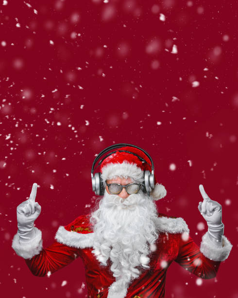 cool santa claus está ouvindo música em fones de ouvido. cartaz vermelho - seu texto. - santa claus audio - fotografias e filmes do acervo