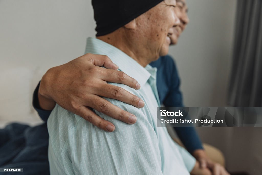 Father and son enjoy talking in bedroom. Cancer, domestic life. patient, lifestyle. Cancer - Illness Stock Photo