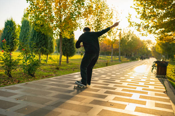 istock Young man riding longboard in sunny weather 1438345887