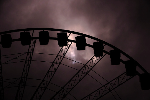 A ferris wheel surrounded by dark clouds