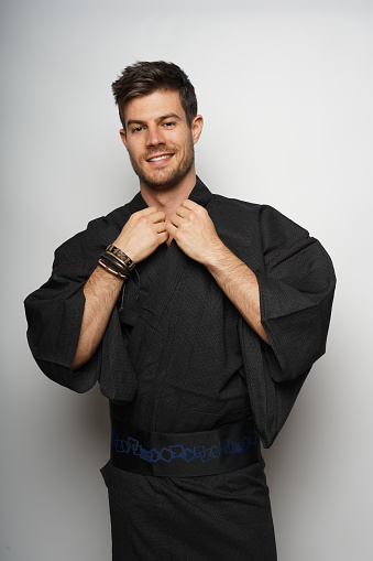 A vertical shot of a male wearing Japanese style kimono and smiling