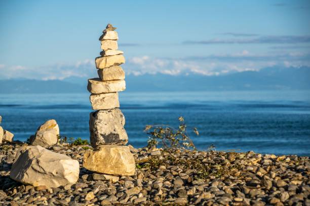 istock Stone pyramids on the lake shore with mountain view and sunshine 1438350582
