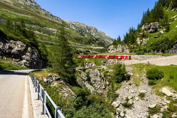 A typical Swiss touristic red train climbing up the Furka railway in Switzerland