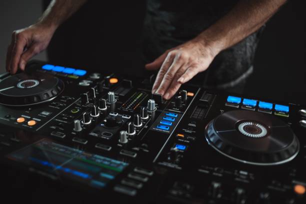 istock Closeup of a DJ working under the lights against a dark background in a studio 1438351288