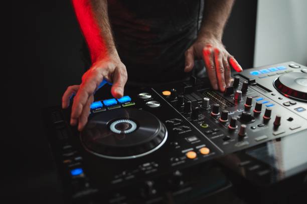 istock Closeup of a DJ working under the lights against a dark background in a studio 1438351292