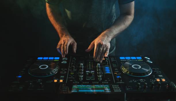 istock Closeup of a DJ working under the lights against a dark background in a studio 1438351318