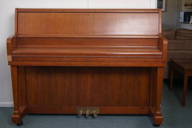istock Brown piano against a white wall under the lights in a house 1438353606