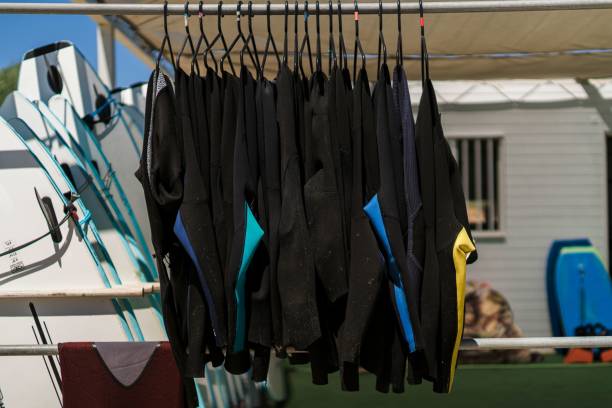istock View of black surfing wetsuits hung from a beachside shop 1438353966