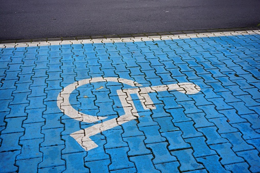 A high angle closeup shot of the handicapped symbol on the blue cobblestone ground