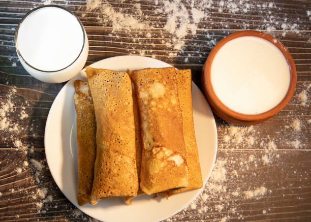 Top view. Pancake rolls with a glass of milk and sour cream in pot stock photo