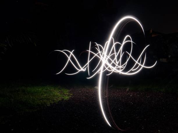 istock Dark abstract background with white motion paint lights on grass field 1438355103