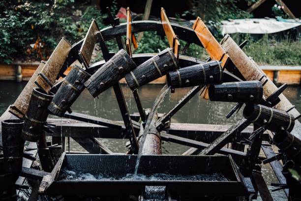 istock Irrigation water wheel on a river with green trees in the background 1438355319