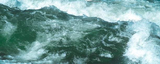 Wild waves at a fast rapids. Cold icy Eisbach in munich closeup. Brave people surf here in all seasons