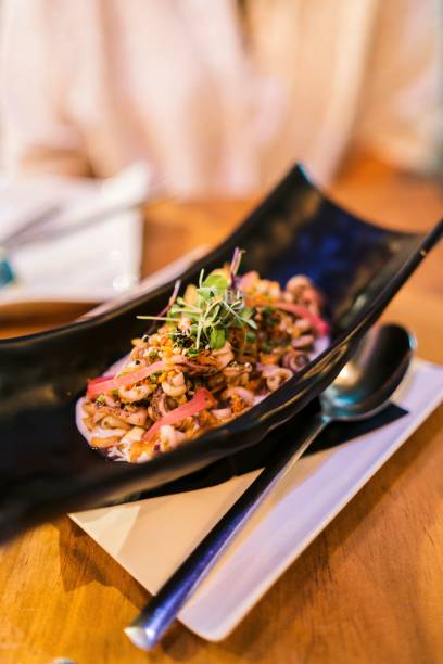 istock Vertical high-angle view of a seafood salad served on a decorative black plate 1438355818