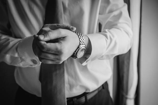 istock man putting clock on hand,groom getting ready in the morning 1438356861